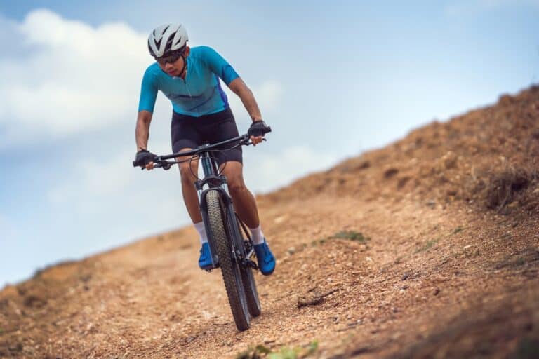 A biker riding his dual suspension bike through the mountain trail.