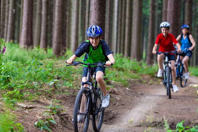 Teenagers biking on a mountain trail.