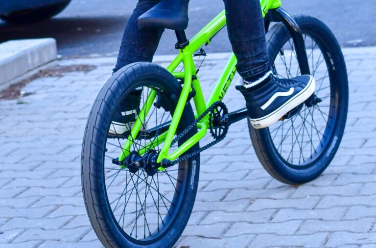 A person riding a bmx with vans shoes.