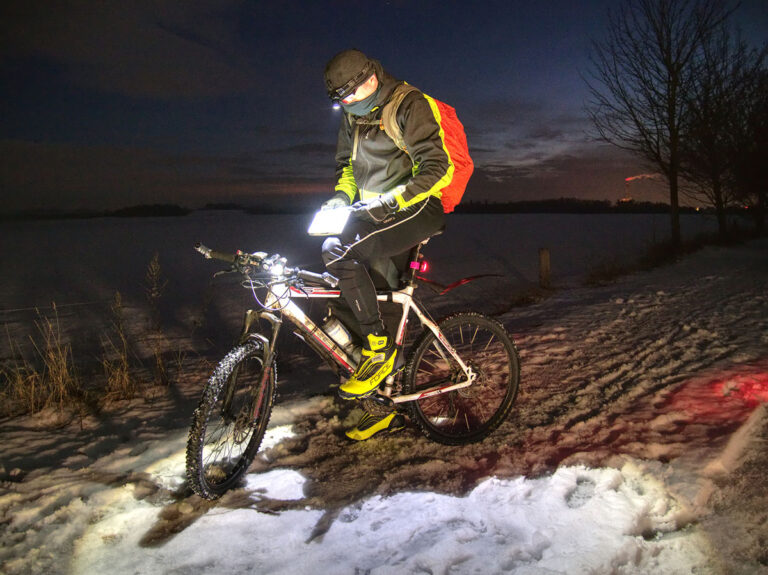 A person on a bicycle riding at night.