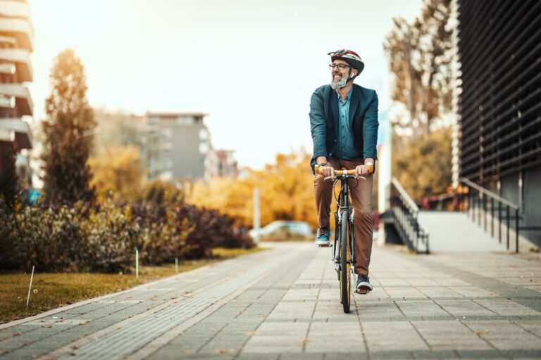 An old man biking at the city pavement.