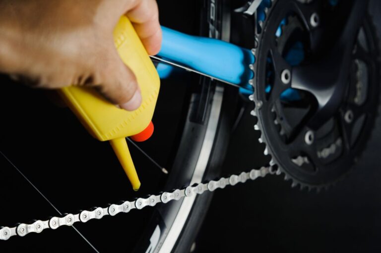 A man placing oil on his mountain bike.