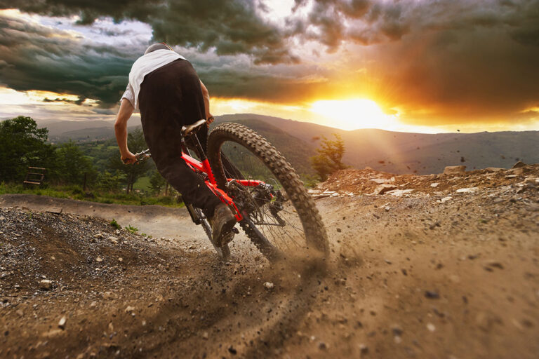 A cyclist drifting on a dirt road.