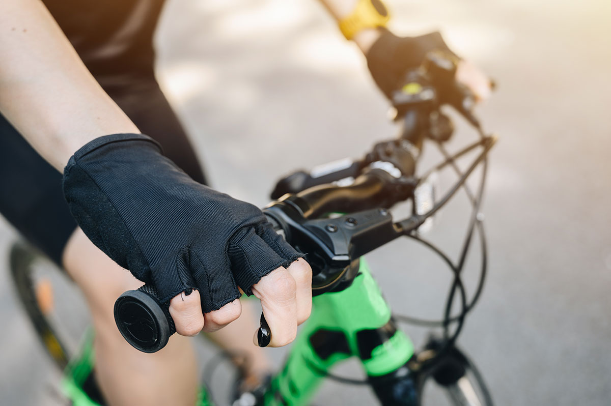 A person with a gloves on a mountain bike holding a brake.