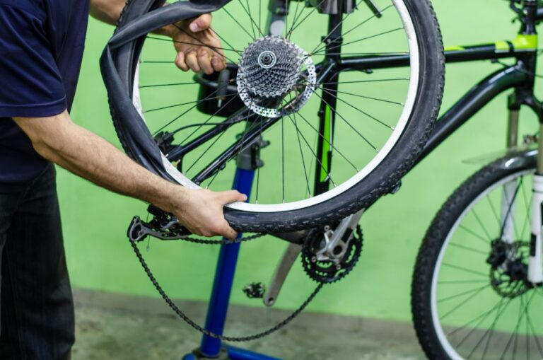 A man replacing a tire of a mountain bike.