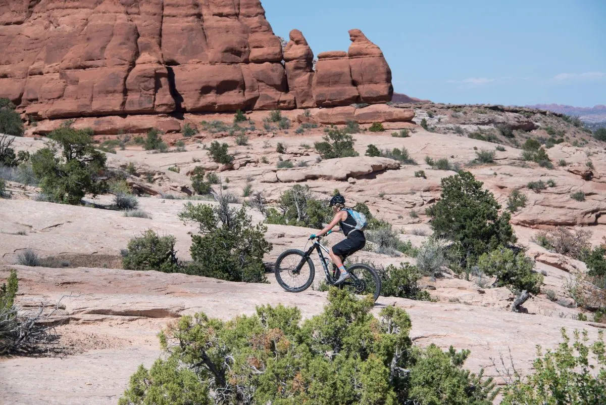 A person biking on the dessert and rocky mountains.