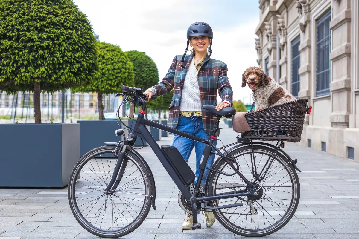 A woman on her e-bike with a pet.