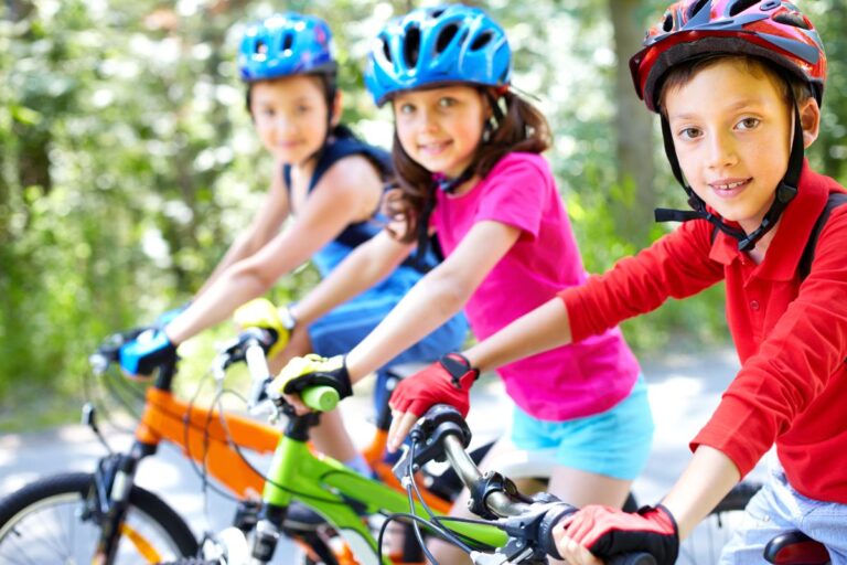 Kids on full gear riding their mountain bike.